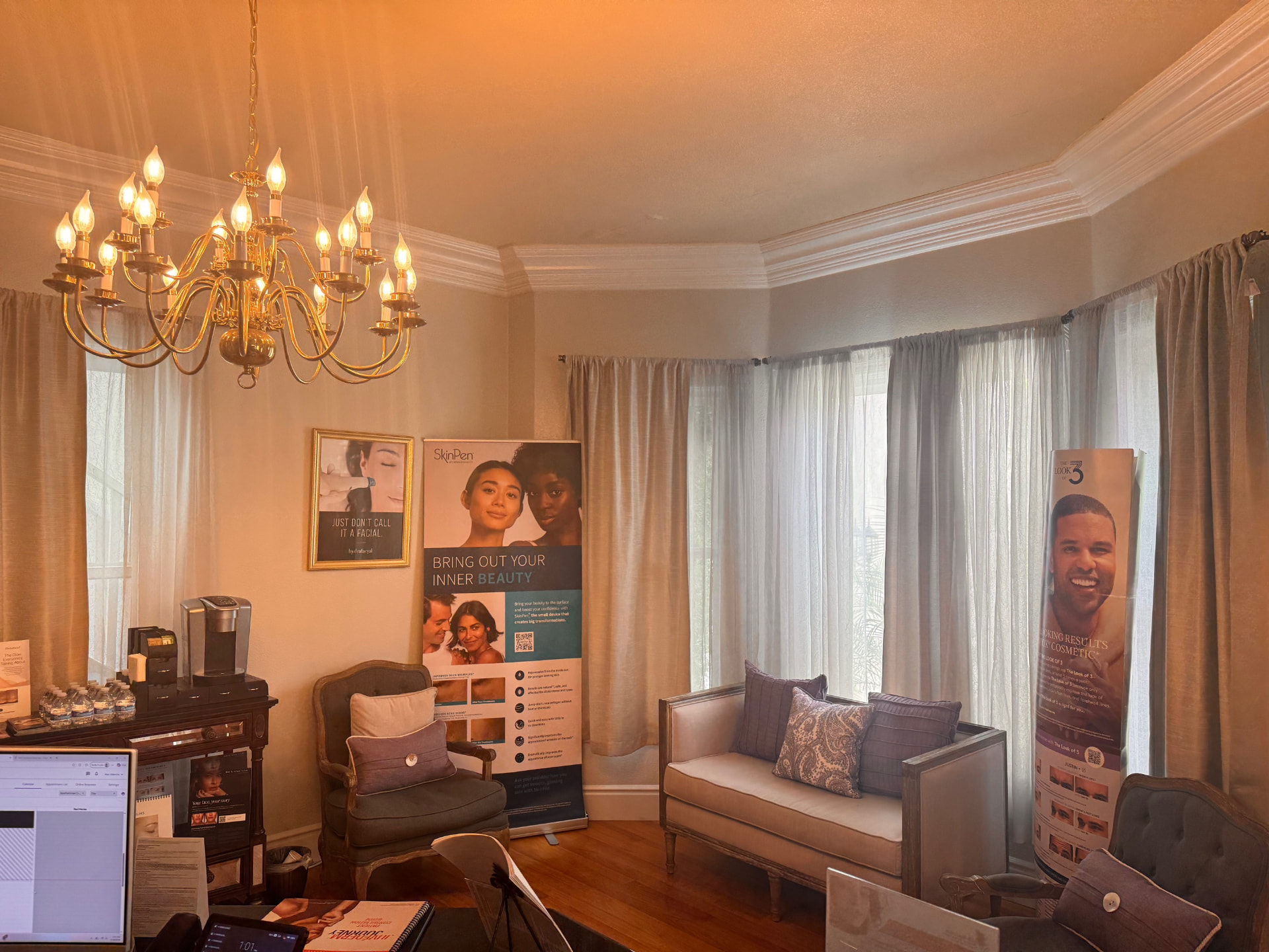 The Bella Aesthetica waiting area with chandelier and product displays